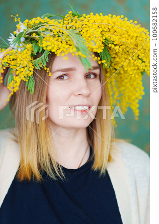 middle-aged woman in a wreath of mimosa middle-aged woman in a wreath of mimosa 100682158