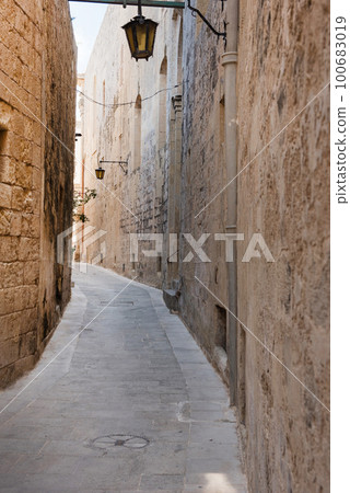 Narrow medieval street with stone houses in Mdina, Malta 100683019