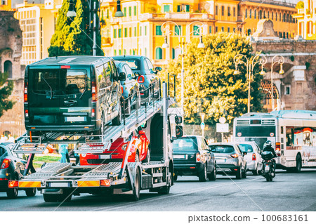 Auto-transport Carrying New Fiat Cars In European City Street. Auto Transport Broker Or Car Transporter. Auto-transport Carrying New Fiat Cars In City Street. Auto Transport Broker Or Car Transporter. 100683161