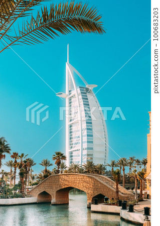 View of Hotel Burj Al Arab, Tower of the Arabs is luxury hotel located in city of Dubai, United Arab Emirates. Managed by Jumeirah hotel group. Madinat Jumeirah is shopping, hotel and business center 100683203