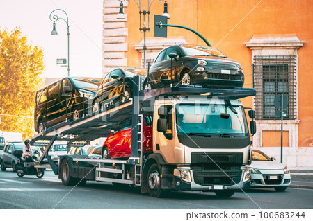 Auto-transport Carrying New Fiat Cars In European City Street. Auto Transport Broker Or Car Transporter 100683244