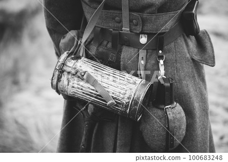 Re-enactor Dressed As German Wehrmacht Infantry Soldier In World War Ii On Marsch. View From Back. German Military Dress Of A German Soldier At World War II. Black And White Colors 100683248