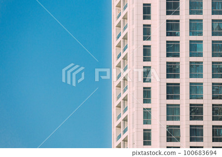 Wall With A Balcony Of New Empty Modern Multi-storey Residential Building House In Residential Area On Sunny Blue Sky Wall With A Balcony Of New Empty Modern Multi-storey Residential Building House In Residential Area On Sunny Blue Sky 100683694