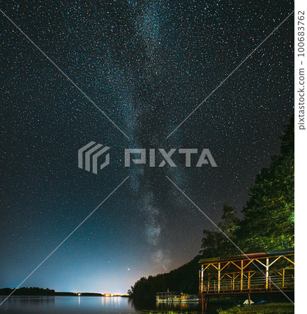 Night Stars Above Lake. Milky Way Galaxy And Natural Starry Sky Background Backdrop Landscape Night Stars Above Lake. Milky Way Galaxy And Natural Starry Sky Background Backdrop Landscape 100683762