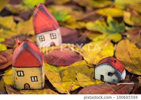Painted toy houses on autumn leaves Painted toy houses on autumn leaves 100685594