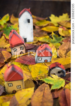 Painted toy houses on autumn leaves Painted toy houses on autumn leaves 100685595