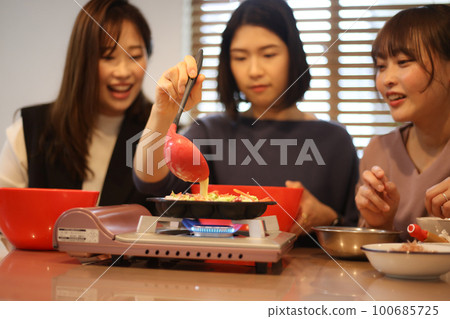 Woman making takoyaki Woman making takoyaki 100685725