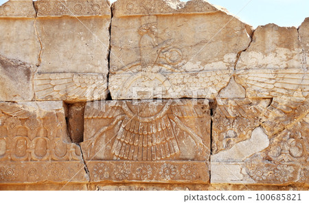Ancient wall with bas-relief of Zoroastrian god Faravahar (Frahvahar), Persepolis, Iran. UNESCO world heritage site Ancient wall with bas-relief of Zoroastrian god Faravahar (Frahvahar), Persepolis, Iran. UNESCO world heritage site 100685821