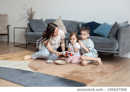 Mother and children have breakfast on the floor. Mother and children have breakfast on the floor. 100687906