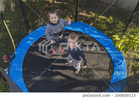 children jump on the trampoline children jump on the trampoline 100689113
