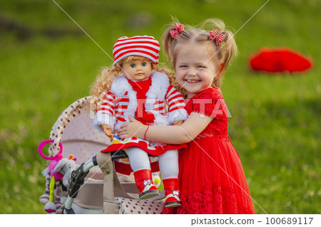 Girl playing with a doll in nature Girl playing with a doll in nature 100689117