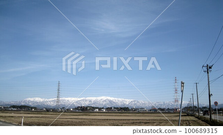 Snowy mountains, transmission line towers and rice fields Snowy mountains, transmission line towers and rice fields 100689315