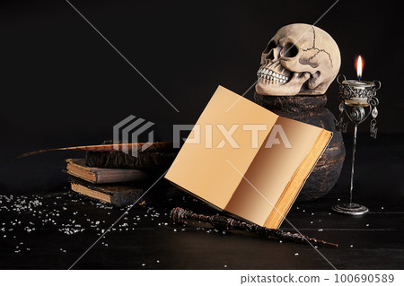Realistic model of a human skull with teeth on a wooden dark table, black background. Medical science or Halloween horror concept. Close-up shot. 100690589