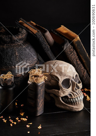 Realistic model of a human skull with teeth on a wooden dark table, black background. Medical science or Halloween horror concept. Close-up shot. 100690631