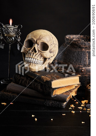 Realistic model of a human skull with teeth on a wooden dark table, black background. Medical science or Halloween horror concept. Close-up shot. Realistic model of a human skull with teeth on a wooden dark table, black background. Medical science or Halloween horror concept. Close-up shot. 100690691