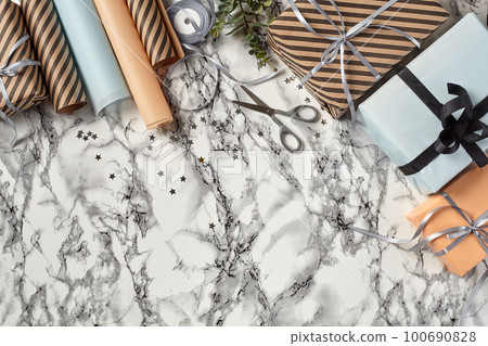 Different sizes, striped and plain paper gift boxes tied with ribbons and bows on a marble background. Close-up, copy space, top view. Different sizes, striped and plain paper gift boxes tied with ribbons and bows on a marble background. Close-up, copy space, top view. 100690828