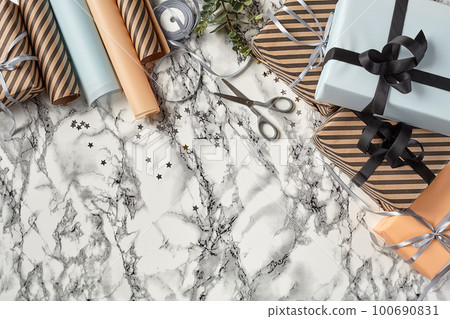 Different sizes, striped and plain paper gift boxes tied with ribbons and bows on a marble background. Close-up, copy space, top view. Different sizes, striped and plain paper gift boxes tied with ribbons and bows on a marble background. Close-up, copy space, top view. 100690831