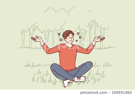 Young guy sits in lotus position on lawn doing yoga and meditating to restore strength 100691868