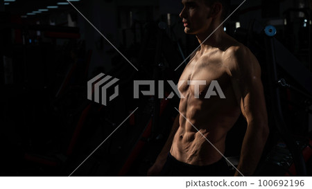 Shirtless man with sculpted body in the gym. Shirtless man with sculpted body in the gym. 100692196