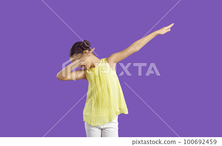 Happy funny girl with hair buns standing isolated on purple background and doing dab gesture Happy funny girl with hair buns standing isolated on purple background and doing dab gesture 100692459