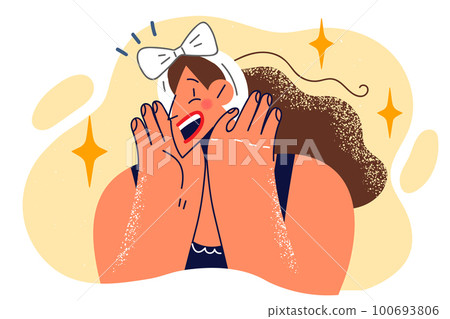 Embarrassed woman with bow on long hair putting hands on cheeks admires and opens mouth wide 100693806
