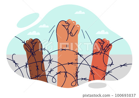 Hands of protesters are clenched into fist near barbed wire restrict movement of illegal migrants 100693837