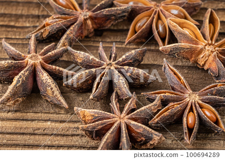 Dried star anise spice on vintage wooden board 100694289