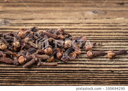 Clove spice on a wooden board, Syzygium aromaticum 100694290