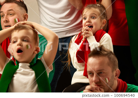 Tense moment. Football, soccer fans emotionally cheering up favourite team during match. Men visiting game with kids 100694540