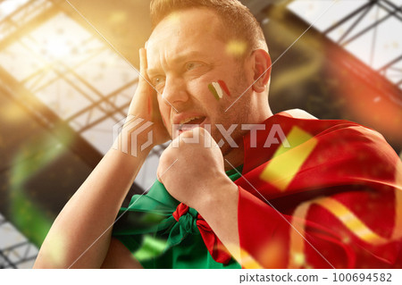 Tense moment. Football, soccer fan, mature man emotionally watching live match, competition. Worried face during game. Fans cheering up team Tense moment. Football, soccer fan, mature man emotionally watching live match, competition. Worried face during game. Fans cheering up team 100694582