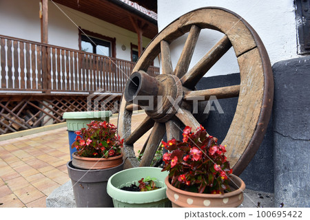 Vintage wooden wheel in a rural yard Vintage wooden wheel in a rural yard 100695422