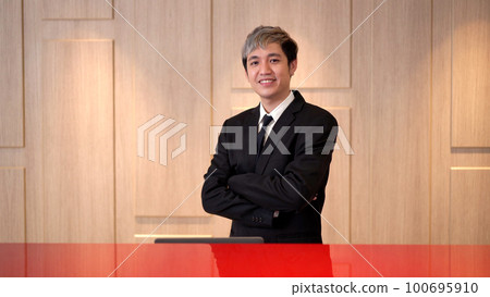 Handsome Asian young businessman making an arms crossed and looking at the camera, Asian businessman's portrait close up with copyspace. 100695910