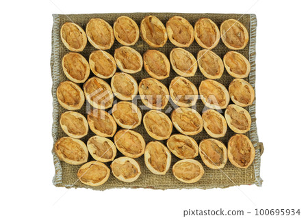 Shell of walnuts in brown bag isolated on a white background. Bio-waste. Top view. 100695934