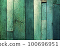 Texture background made up of old, uneven boards with a range of dark green colors and shades. The surface of the boards appears worn and weathered, with visible cracks and natural defects. 100696951