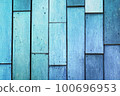Background made of old, light blue boards. The weathered texture and faded color of the boards give a sense of age and history. The simplicity of the image creates a calm and peaceful atmosphere 100696953