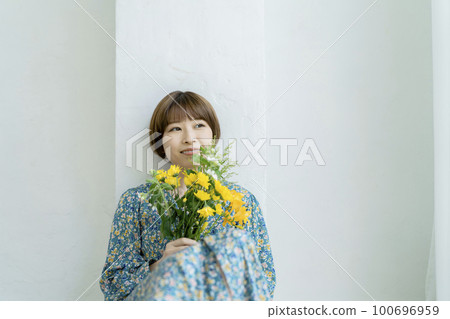 Portrait of a young woman holding a bouquet Portrait of a young woman holding a bouquet 100696959