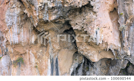 Texture of big rock formation. Old weathered eroded rock close up. Geological scenery. 100698544