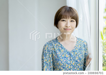 一個年輕女子的肖像微笑著看著相機 一個年輕女子的肖像微笑著看著相機 100698701