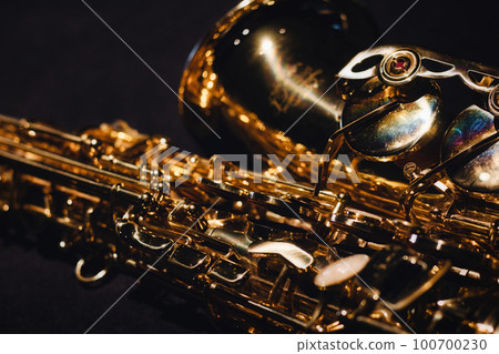 Close-up of intricate details of a shiny saxophone musical instrument Close-up of intricate details of a shiny saxophone musical instrument 100700230
