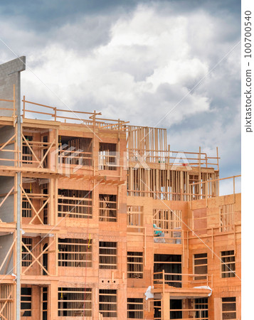 Apartment building under construction on cloudy sky background Apartment building under construction on cloudy sky background 100700540