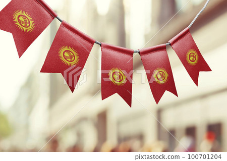 A garland of Kirghizia national flags on an abstract blurred background 100701204