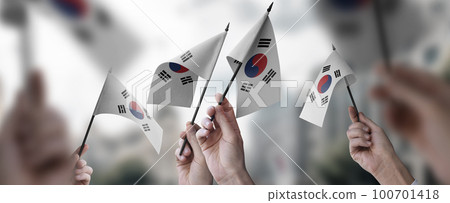 A group of people holding small flags of the South Korean in their hands 100701418