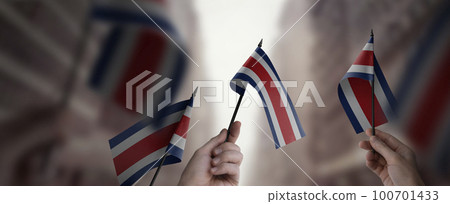 A group of people holding small flags of the Costa Rica in their hands A group of people holding small flags of the Costa Rica in their hands 100701433