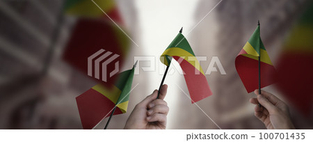 A group of people holding small flags of the Congo in their hands A group of people holding small flags of the Congo in their hands 100701435