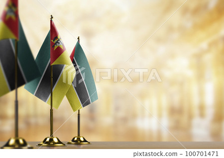 Small flags of the Mozambique on an abstract blurry background 100701471