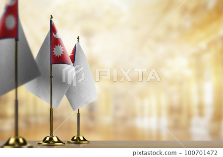 Small flags of the Nepal on an abstract blurry background Small flags of the Nepal on an abstract blurry background 100701472