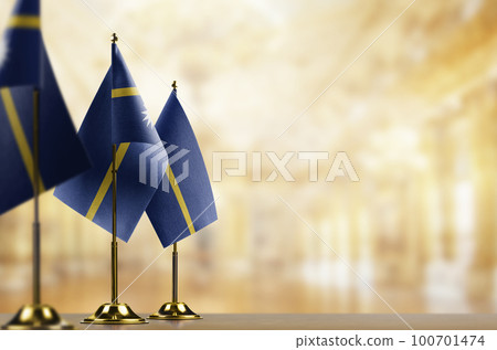 Small flags of the Nauru on an abstract blurry background 100701474