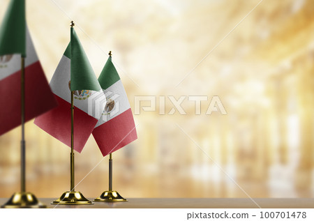 A small Mexico flag on an abstract blurry background 100701478