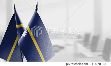 Small flags of the Nauru on an abstract blurry background 100701612