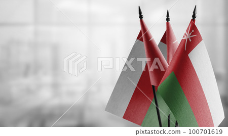 Small flags of the Oman on an abstract blurry background 100701619